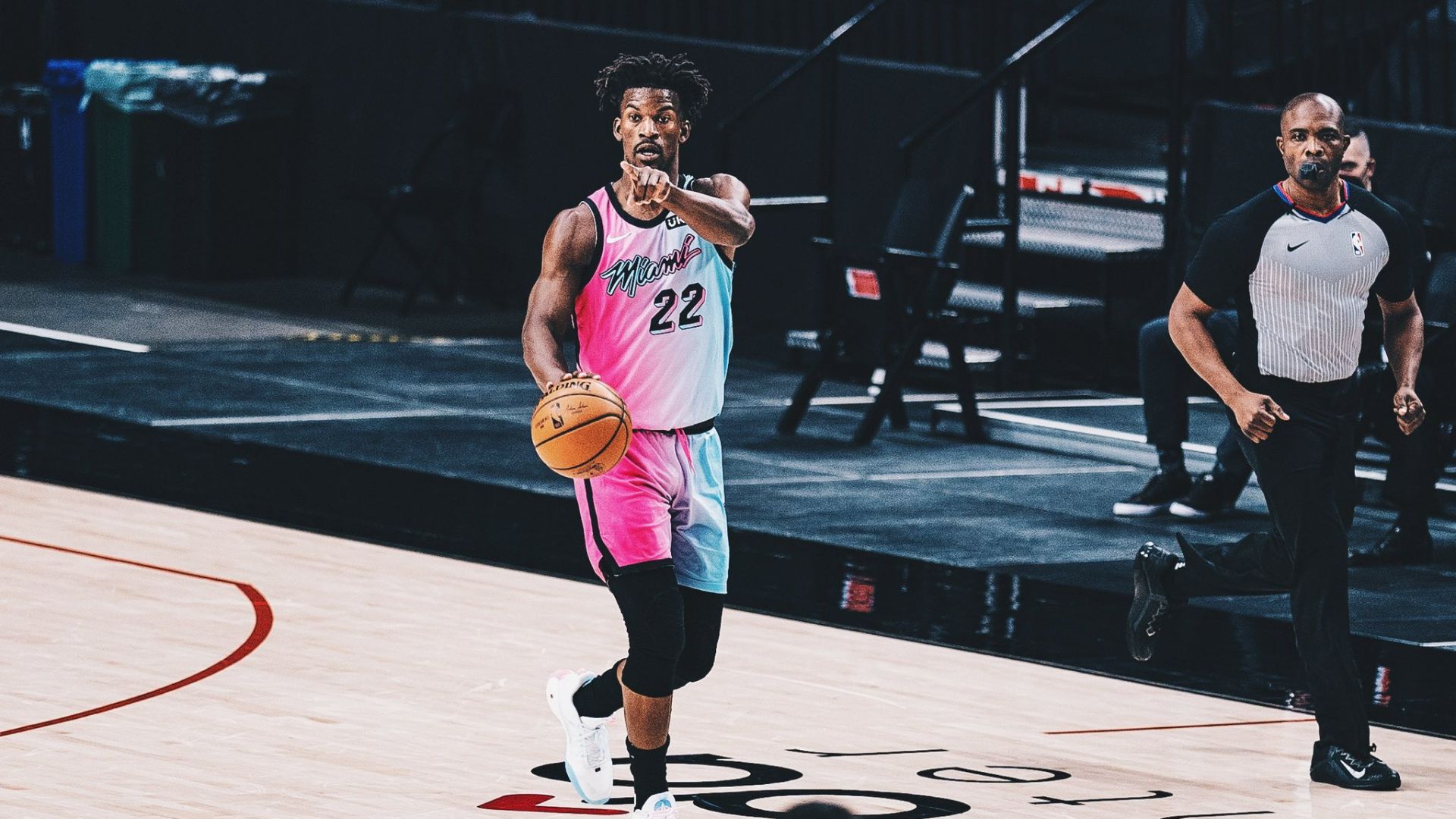 Jimmy Butler pointing at his teammate while holding the ball.