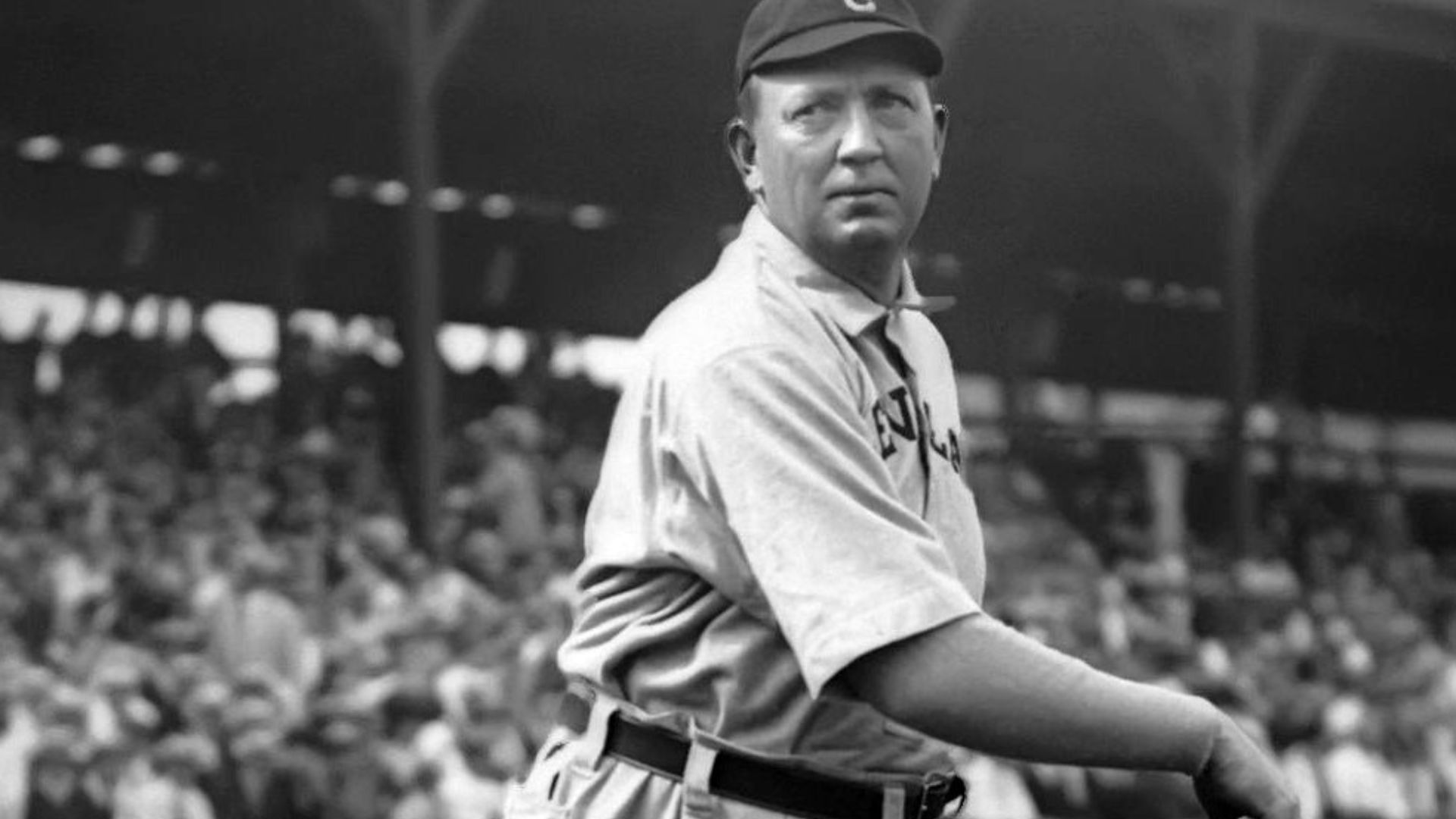 A man looking straight after throwing a ball.