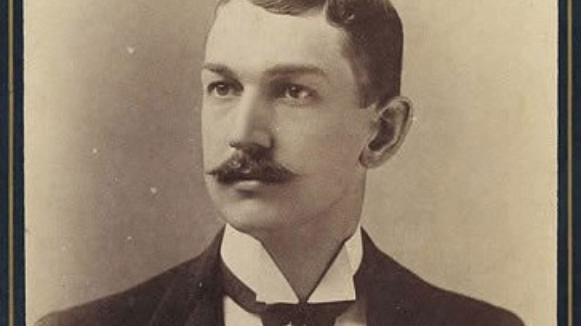 A man with mustache posting in the camera