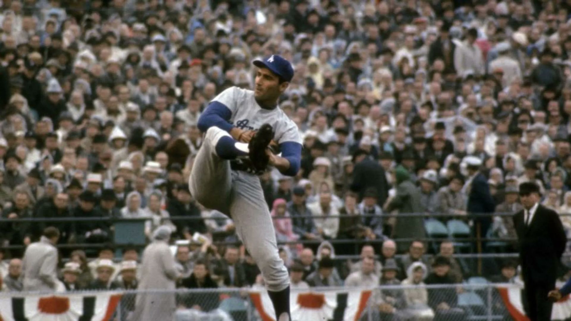 A baseball player throwing the ball with his left foot raised.